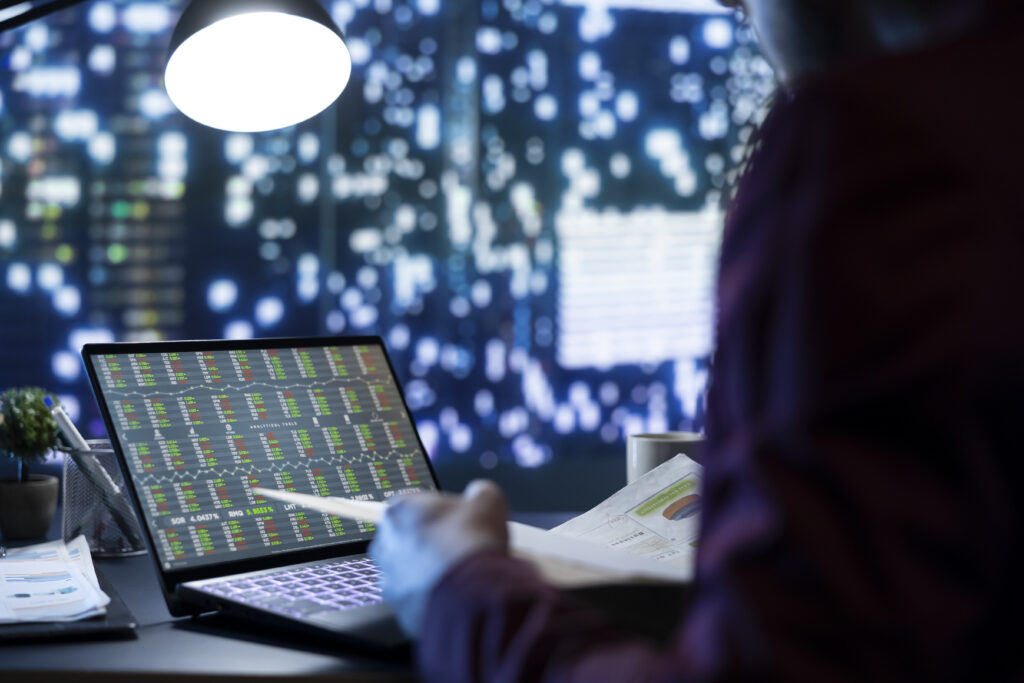 stock market analyst reviews monthly financial operations at night